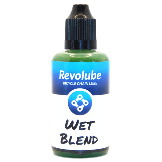 A 50ml plastic bottle of Revolubes Wet Blend bicycle chain lube with a precision applicator, designed for use in wet weather conditions.